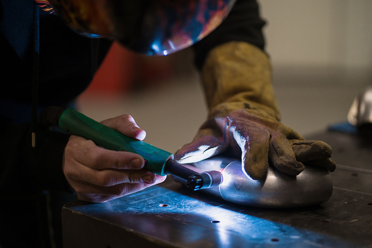 Man working with argon welding machine in a garage